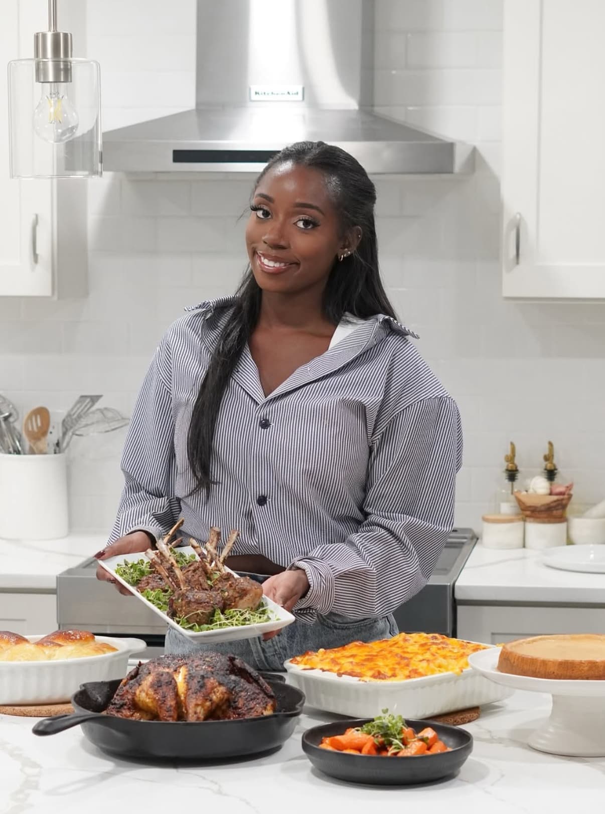 Taina in her kitchen with a spread of dishes